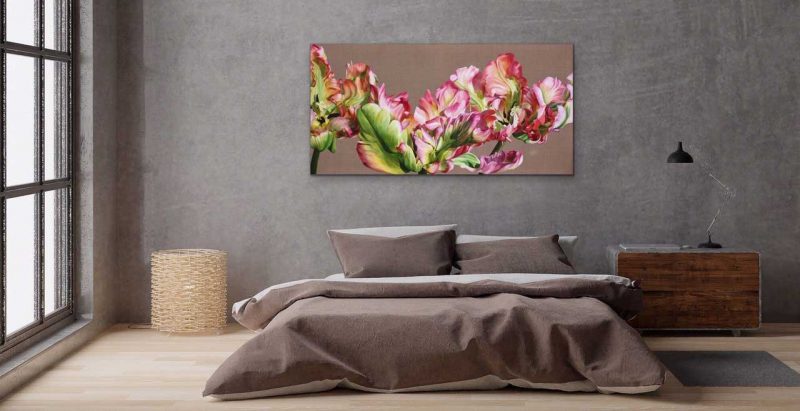 Canvas print of pink and green parrot tulips on linen on a wall over a bed. Painting by UK floral artist Sarah Caswell