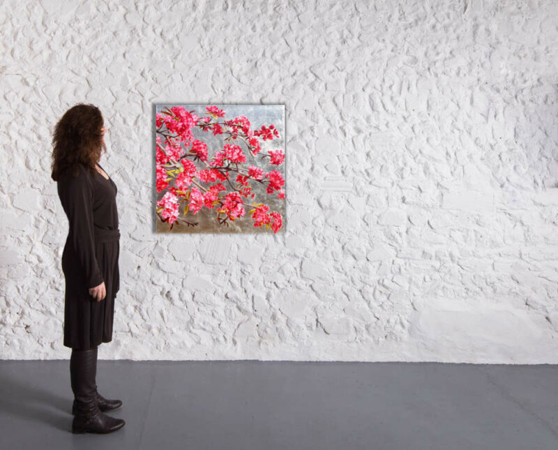 Original painting of magenta blossom on a silverbackground in a gallery